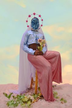 a woman sitting on top of a wooden chair wearing a dress and headdress