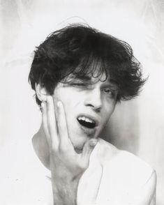 black and white photograph of a young man with his hands on his face as if he were screaming