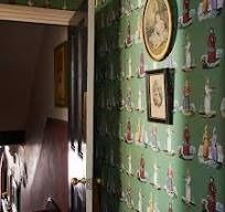 a bathroom with green wallpaper and pictures on the wall next to the sink area