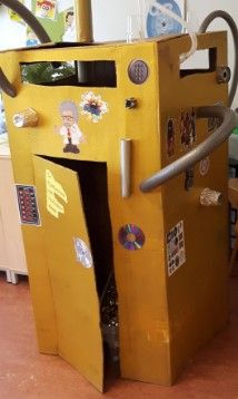 a yellow cardboard box with stickers on it and a hose sticking out of the door