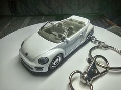 a white car keychain sitting on top of a table