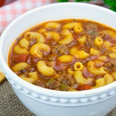 a white bowl filled with pasta and meat soup