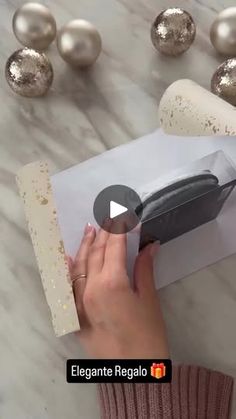 a woman is opening a package with a knife in it on a marble counter top