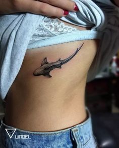 a woman's stomach with a shark tattoo on her belly and the bottom part of her stomach