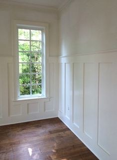 empty room with hard wood flooring and white paint on the walls, windows and doors