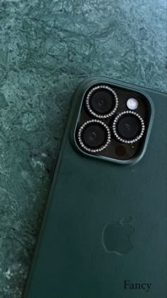 an iphone case with four cell phones in it on a marble countertop next to a green apple phone