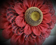 a large red flower with black and white stripes on it's center is surrounded by netting