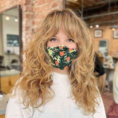 a woman with long hair wearing a face mask