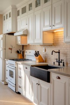 Traditional white kitchen with black sink, cream counter tops, and gold hardware in the kitchen Black Farmhouse Sink, Black Farmhouse