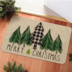 a merry christmas door mat with pine trees