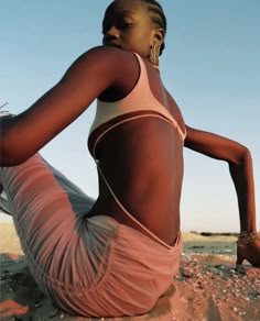 a woman is sitting on the beach with her legs crossed