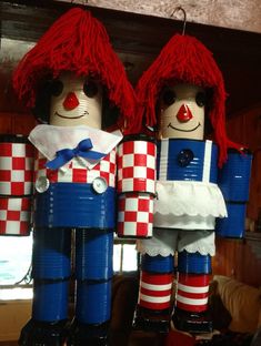 two wooden nutcrackers dressed in red and white checkered outfits, standing next to each other