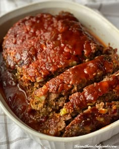 meatloaf in a white dish with sauce on top