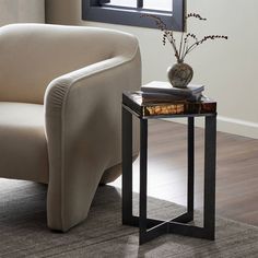 a living room with a couch, table and chair next to the window in front of it