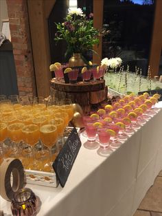 a table topped with lots of glasses filled with different types of drinks and desserts