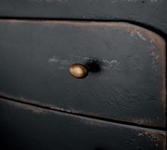 an old black dresser with brass knobs and rusted metal handles is seen in this image