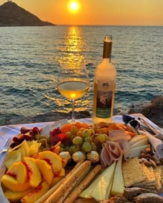 a glass of wine sitting next to a platter of cheeses and crackers