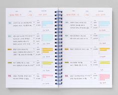 a spiral bound planner is open on top of a white surface with colorful lines and numbers