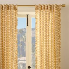 an open window with yellow curtains in front of it