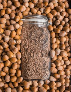 a jar filled with nuts sitting on top of a pile of other nuts