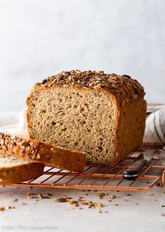 a loaf of gluten free seed loaf sitting on top of a cooling rack