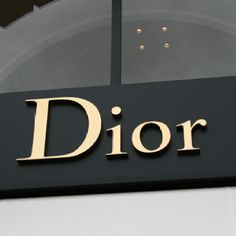 a black and gold sign with the word dior on it's front door