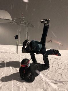 a snowboarder laying on his back in the snow