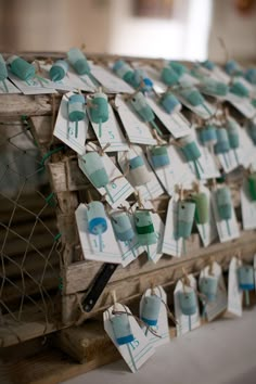 several tags hanging from a wooden structure on a string and tied to a wire fence