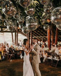 a bride and groom dancing under disco balls