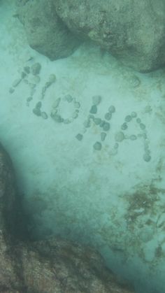 the word hope is written in sand on the bottom of some rocks and under water