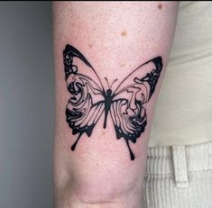 a black and white butterfly tattoo on the arm