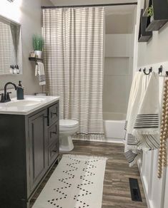 a bathroom with a sink, toilet and shower curtain