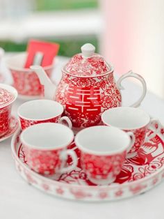 a red and white tea set on a table