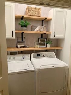 a washer and dryer in a small room with open shelving on the wall