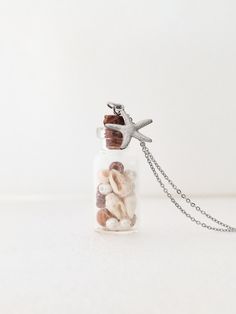 This is an adorable beach-in-a-bottle necklace with a small glass bottle pendant containing shells and pearls. The bottle is closed with a Portuguese cork stopper and it also comes with a stainless steel chain and a starfish charm. You can choose the length of the chain. The Portuguese cork on this necklace is of great quality! It is soft, durable, also stain and water resistant. It is completely vegan, and 100% natural. Also, Portuguese cork is sustainably harvested, so trees are never cut down Necklace Bottle, Tiny Jar Necklace, Mini Bottles Necklace, Cork Necklace, Tiny Bottle Necklaces, Fairy Bottle Necklace, Cork Jewelry, Small Glass Bottles, Mini Glass Bottles