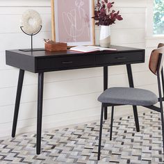 a desk with a chair next to it and a book on top of the desk