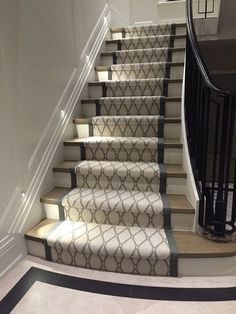 the stairs in this house are decorated with white and gray carpeting, along with black railings