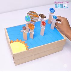 a kid is playing with some sort of sun and planets on a piece of cardboard