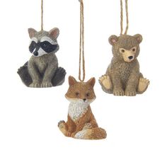 three ornaments with animals hanging from strings on a white background, each featuring a raccoon and a raccoon