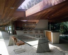 an open kitchen and dining room area in a modern house with wood paneling on the ceiling