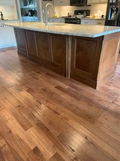 a kitchen with an island and wooden floors