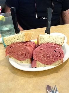 there is a plate with two halves of a sandwich on it and a fork next to it