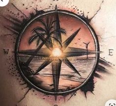 a man's back with a compass and palm trees in the center on it