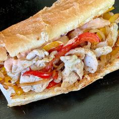 a sub sandwich with chicken, peppers and onions