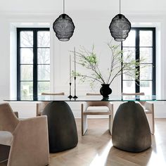 a dining room table with chairs and a vase