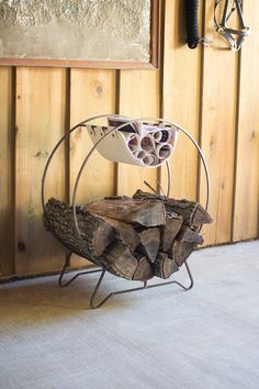 a stack of wood sitting on top of a metal stand next to a wooden wall