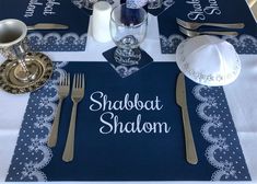 a place setting with silverware and napkins on a blue table cloth that says shaboot shallon