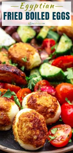 fried boiled eggs on a platter with tomatoes, cucumbers and other vegetables