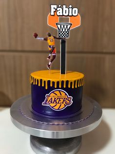 a birthday cake with a basketball player on top and the name fabio above it