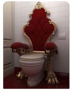 a red chair sitting on top of a white toilet next to a tall golden throne